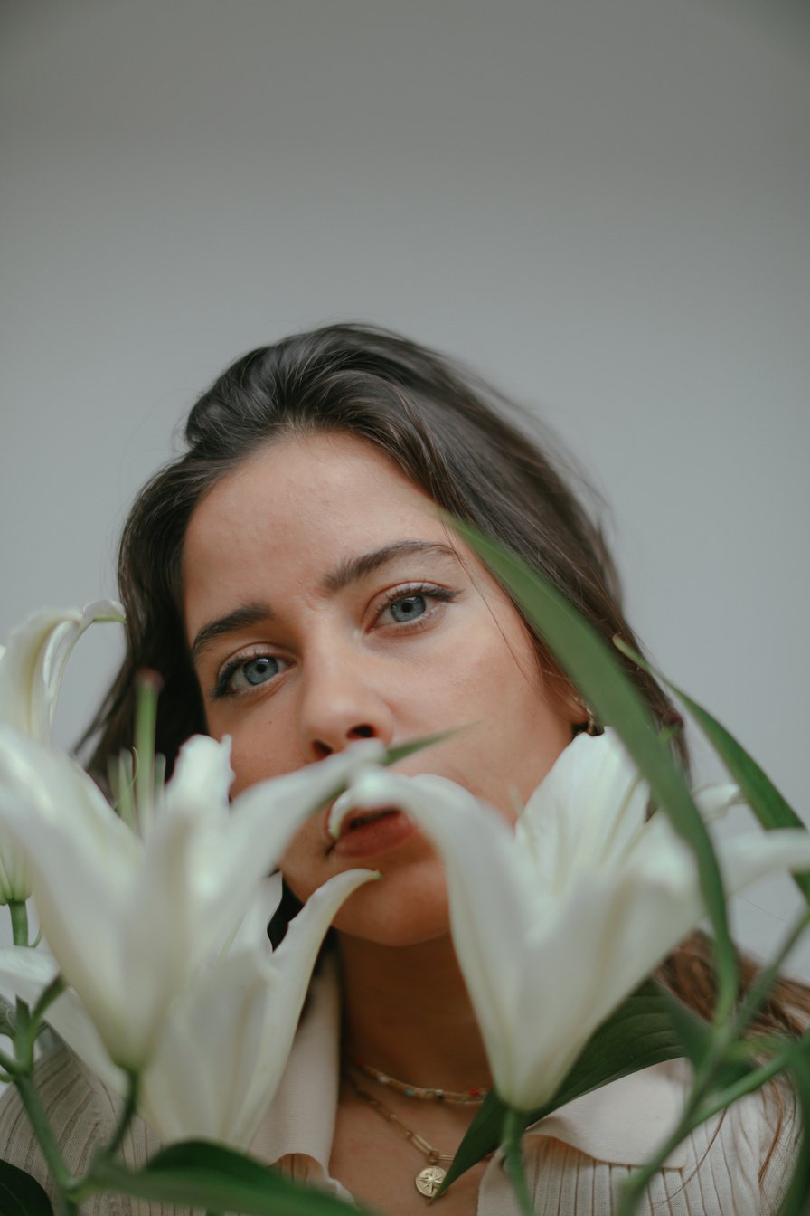 Woman in Green Eye Shadow on White Flower